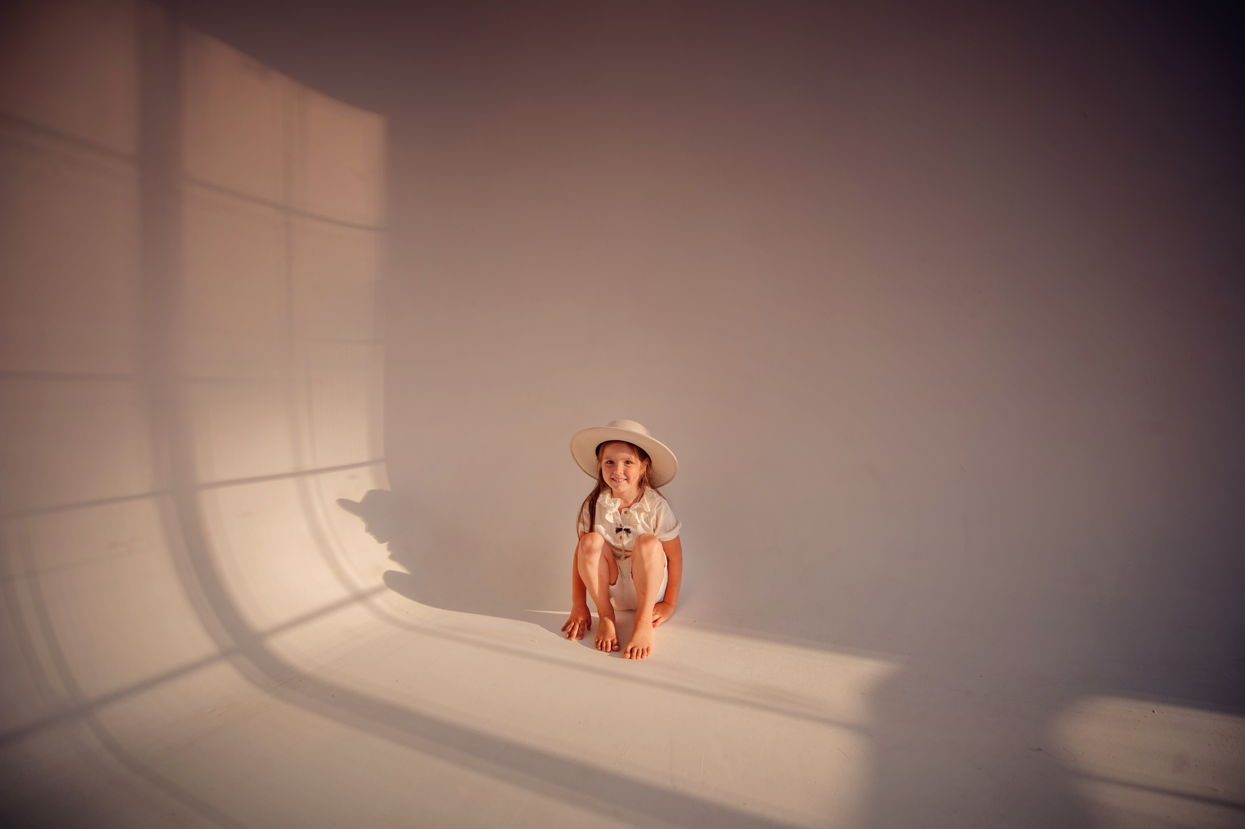 Little girl in white clothes in photo studio